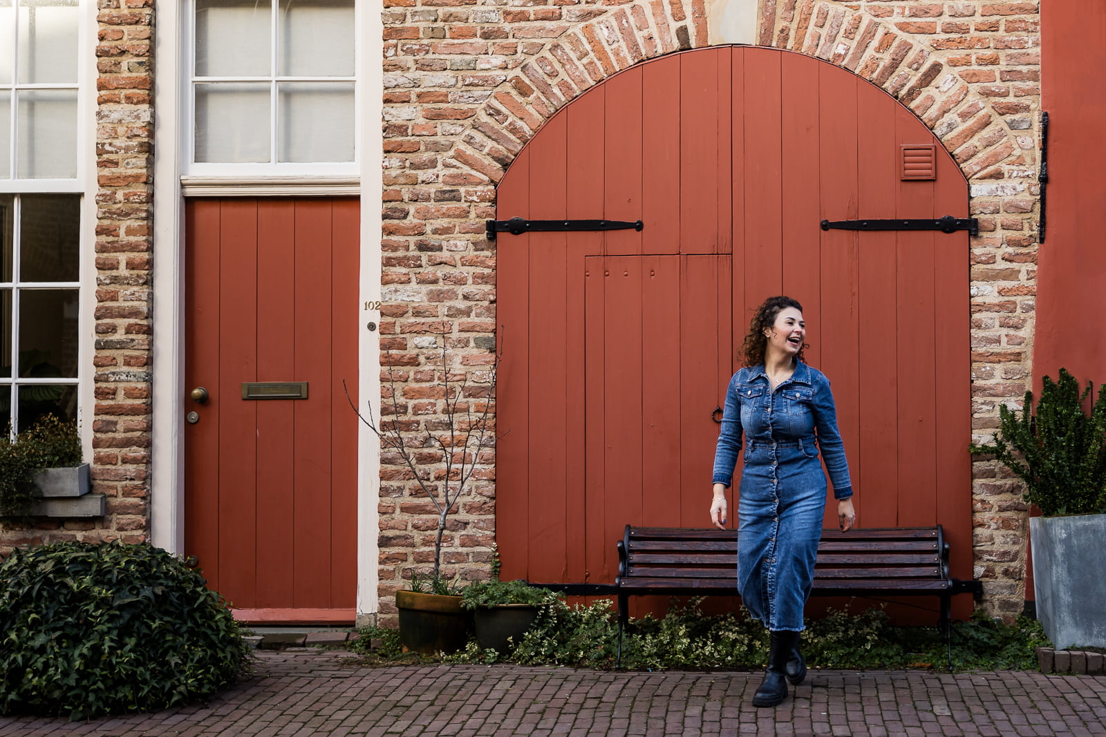 Nermin van Nidak Coaching loopt langs een rode deur in Deventer